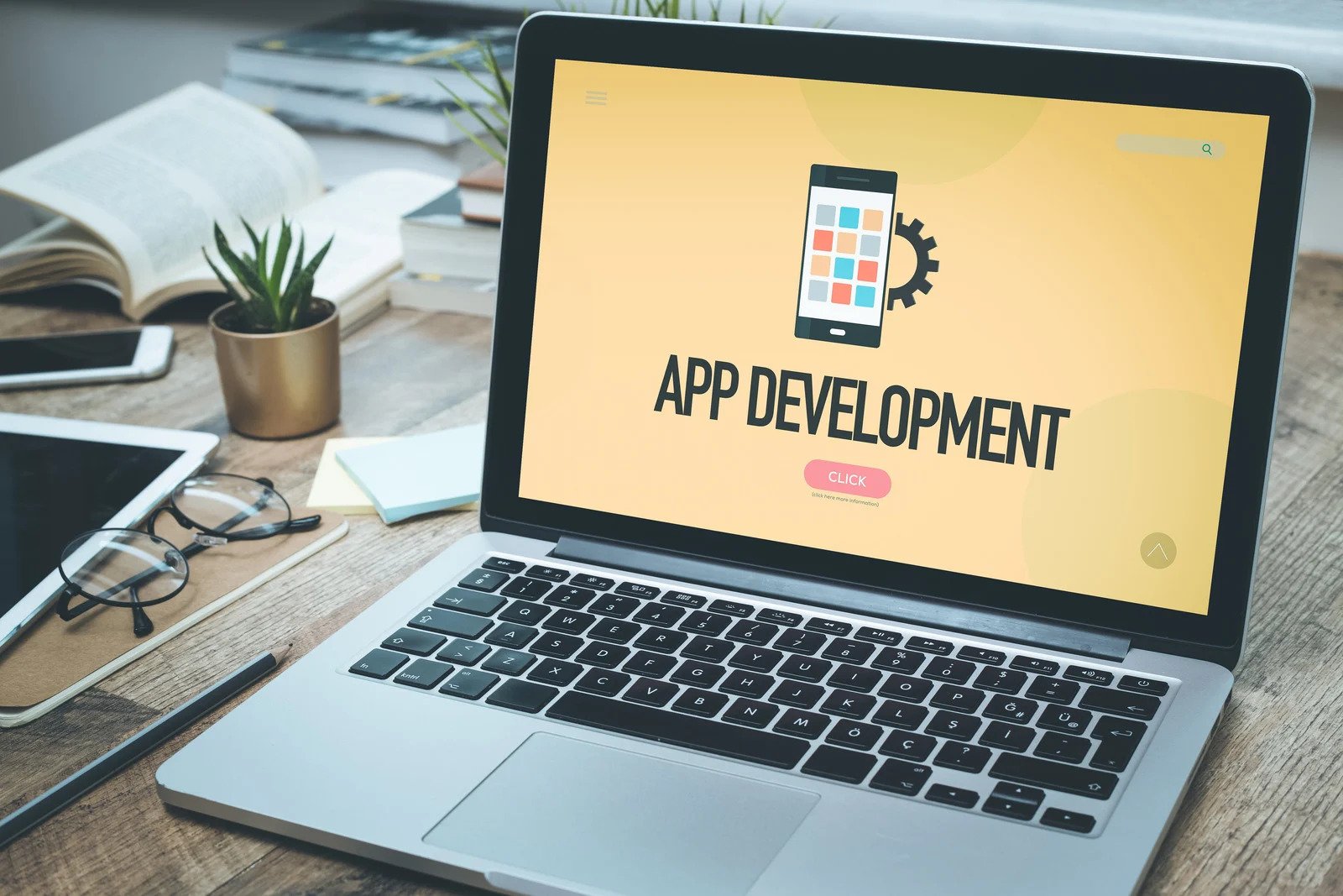 An image of a laptop displaying "app development" on-screen.